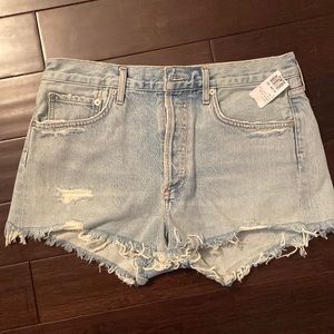 Light wash Agolde jean shorts w/ distressed holes and designed back pocket. NEW